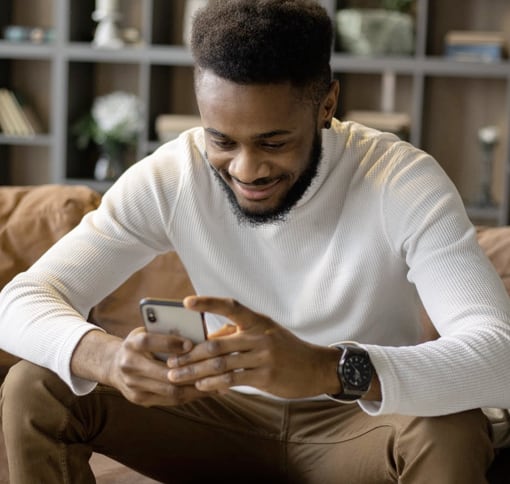 man sitting ob couch texting